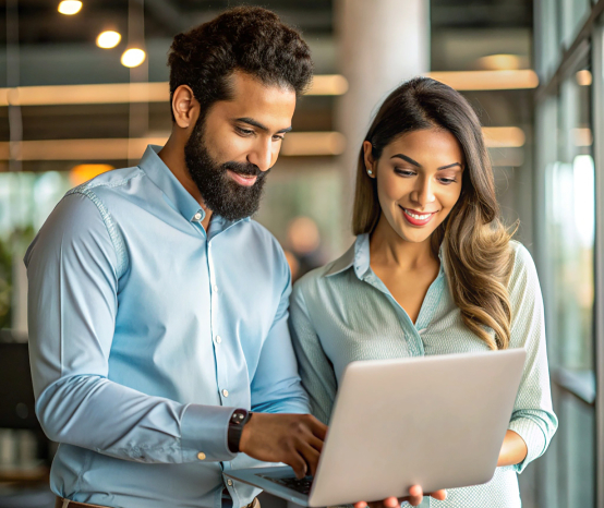 Professionals collaborating on a laptop in a modern office setting, emphasizing teamwork and digital marketing strategies for enhanced brand visibility.